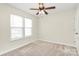 Cozy bedroom with a ceiling fan and two windows providing natural light; neutral walls and carpet throughout at 5323 Dewmorn Pl, Charlotte, NC 28269