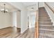 Bright entryway featuring wood flooring, a staircase, and natural light streaming through the doorway at 5323 Dewmorn Pl, Charlotte, NC 28269
