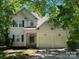 Charming two-story home boasts a two-car garage and a well-maintained front yard with mature trees at 5323 Dewmorn Pl, Charlotte, NC 28269