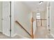 Upstairs hallway featuring carpet, a window, a wood railing, and neutral wall paint at 5323 Dewmorn Pl, Charlotte, NC 28269