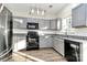 Modern kitchen featuring gray cabinets, granite countertops, stainless steel appliances, and ample natural light at 5323 Dewmorn Pl, Charlotte, NC 28269