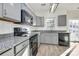 Modern kitchen featuring gray cabinets, granite countertops, stainless steel appliances, and ample natural light at 5323 Dewmorn Pl, Charlotte, NC 28269