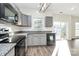 Modern kitchen featuring gray cabinets, granite countertops, stainless steel appliances, and ample natural light at 5323 Dewmorn Pl, Charlotte, NC 28269