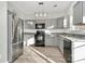 Modern kitchen featuring gray cabinets, granite countertops, stainless steel appliances, and ample natural light at 5323 Dewmorn Pl, Charlotte, NC 28269