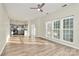 The sunny living room features wood floors, neutral paint, a ceiling fan, and an open floor plan at 5323 Dewmorn Pl, Charlotte, NC 28269