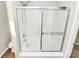 The shower/tub combo features sliding glass doors, white tile, and a shower head at 5323 Dewmorn Pl, Charlotte, NC 28269