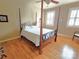Bedroom features four-poster bed, hardwood floors, ceiling fan, and windows providing natural light at 720 9Th Nw Ave, Hickory, NC 28601