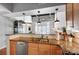Bright kitchen with wood cabinets, stainless steel appliances, and an open view to living room at 720 Governor Morrison St # 207, Charlotte, NC 28211