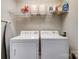 Efficient laundry area featuring a white washer and dryer, with shelving for easy organization and storage at 720 Governor Morrison St # 207, Charlotte, NC 28211