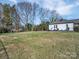 Expansive backyard showcasing a large grassy area and the side of the charming home at 720 Holmes St, Salisbury, NC 28144