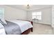 Spacious bedroom with a dark wood bed frame, plush carpet, and a decorative glass table at 805 Deep River Way, Waxhaw, NC 28173