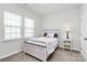 Cozy bedroom features a rustic-style bed frame, soft carpet, and natural light from the large window at 805 Deep River Way, Waxhaw, NC 28173