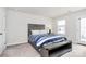 Comfortable bedroom featuring a gray-toned bedframe, a seating bench and a door to the outside at 805 Deep River Way, Waxhaw, NC 28173