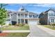 Charming two-story home featuring a well-manicured lawn, covered porch and two-car garage at 805 Deep River Way, Waxhaw, NC 28173