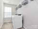 Functional laundry room with a washer, dryer, and storage shelves at 805 Deep River Way, Waxhaw, NC 28173
