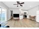 Open-concept living area with wood floors, a television, and a modern, white kitchen in the background at 805 Deep River Way, Waxhaw, NC 28173