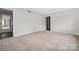 This bedroom has neutral walls, carpet, and a passageway to another room at 8057 Cedar Glen Dr, Charlotte, NC 28212