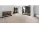 Living room with fireplace, large window, sliding glass door and neutral carpet at 8057 Cedar Glen Dr, Charlotte, NC 28212