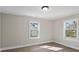 This is a bedroom with neutral walls, light wood floors, and two windows for natural light at 811 Austin St, Albemarle, NC 28001