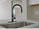 Close-up of kitchen sink featuring stainless fixtures and quartz countertop at 811 Austin St, Albemarle, NC 28001
