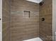 Close-up of tiled shower featuring wood-look tile surround and a tiled niche at 811 Austin St, Albemarle, NC 28001