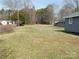 Open backyard with a well-maintained lawn, and a view of home and auxiliary buildings at 915 Chapel St, Landis, NC 28088