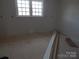 Bright room featuring double windows, fresh neutral paint and plywood flooring, awaiting finishing touches at 915 Chapel St, Landis, NC 28088