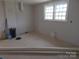 Bright room with double windows, fresh neutral paint and plywood flooring, awaiting finishing touches for added charm at 915 Chapel St, Landis, NC 28088