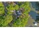 Aerial view of a log home nestled among lush trees on a lake with a private dock at 106 Mcnaron Ln, Mooresville, NC 28117