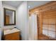 Well lit bathroom featuring vanity with a sink, a shower with a curtain, and wood detail at 106 Mcnaron Ln, Mooresville, NC 28117