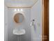 Charming powder room with a pedestal sink, round mirror, and decorative lighting fixtures at 106 Mcnaron Ln, Mooresville, NC 28117