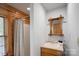 Bathroom features wood trim, a single sink vanity, large mirror, and shower with curtain at 106 Mcnaron Ln, Mooresville, NC 28117