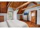 Well-lit bedroom with exposed wood beam ceiling, wood floors, and outdoor access at 106 Mcnaron Ln, Mooresville, NC 28117