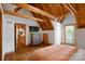 Spacious upstairs bedroom with exposed rafters, wood ceiling, TV, modern furniture, and outdoor access at 106 Mcnaron Ln, Mooresville, NC 28117