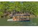 Private dock with covered boat slip and sun deck on a serene lake surrounded by mature trees at 106 Mcnaron Ln, Mooresville, NC 28117