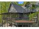 Log home with a large deck, balcony, and many windows surrounded by lush green trees at 106 Mcnaron Ln, Mooresville, NC 28117