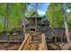 Multi-level home with extensive decks and stairs, nestled among mature trees, offering privacy and scenic views at 106 Mcnaron Ln, Mooresville, NC 28117