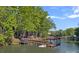 Waterfront property featuring a private dock and covered boat slip, surrounded by lush trees at 106 Mcnaron Ln, Mooresville, NC 28117