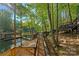 Picturesque wooden walkway winding through lush trees towards a dock and waterfront, ideal for nature lovers at 106 Mcnaron Ln, Mooresville, NC 28117