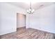 Bright dining room with a modern chandelier, neutral walls, and hardwood floors at 107 Megby Trl, Statesville, NC 28677