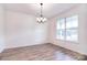 Dining room with a modern chandelier, neutral walls, hardwood floors and bright windows at 107 Megby Trl, Statesville, NC 28677