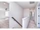 Open hallway with carpet and wood railing leading to bedrooms at 107 Megby Trl, Statesville, NC 28677