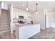 Well-lit kitchen featuring stainless steel appliances, granite island, and staircase at 107 Megby Trl, Statesville, NC 28677