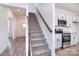 Staircase featuring wood and carpet accents, and a view of the modern kitchen at 107 Megby Trl, Statesville, NC 28677