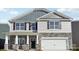Charming two-story home featuring stone accents, gray siding, black shutters, and a white garage door at 121 Meadow View Dr, Statesville, NC 28677