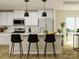 Modern kitchen featuring white cabinets, stainless steel appliances, and black bar stools at 13108 Hampton Bay Ln, Charlotte, NC 28262