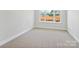 Bedroom filled with natural light and neutral carpet, featuring a large window view of construction at 13126 Macon Hall Dr, Mint Hill, NC 28227