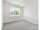Carpeted bedroom showcasing a large window providing ample natural light and outdoor views at 13126 Macon Hall Dr, Mint Hill, NC 28227