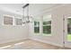 Dining area with large windows offering serene backyard views and contemporary lighting fixture at 13126 Macon Hall Dr, Mint Hill, NC 28227