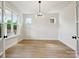 Bright dining room with hardwood floors, modern lighting, and large windows at 13126 Macon Hall Dr, Mint Hill, NC 28227